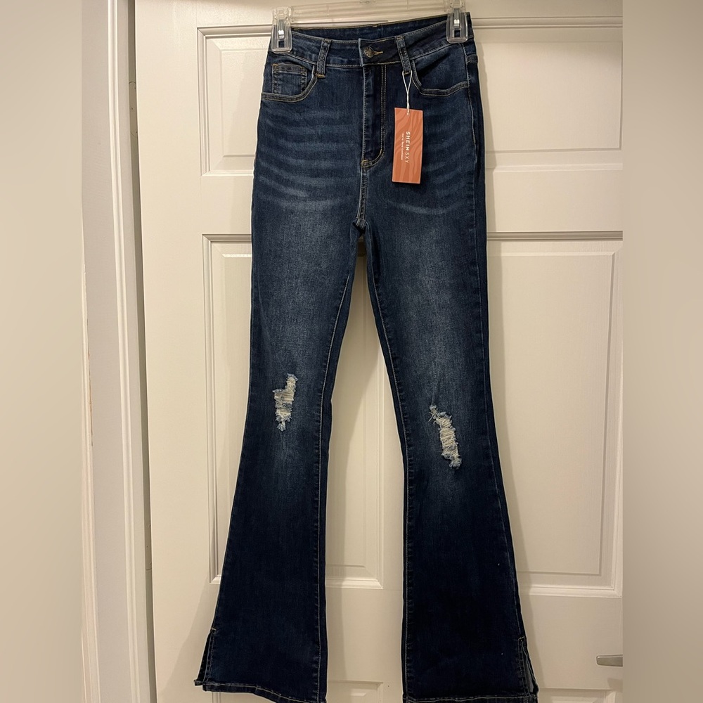 - - - Distressed women's dark blue flared jeans, size w26 L32, open on the…